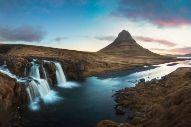 İzlanda 'nın manzaralı görüntüsü. Gün batımında Kirkjufell Şelalesi 'yle Kirkjufell Dağı' nın muhteşem manzarası. Harika doğa manzarası. Popüler seyahat merkezleri. Vahşi bölgenin resmi.