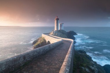 Fırtınalı havalarda Avrupa 'nın en popüler deniz feneri. Gün batımında Petit Minou Deniz Feneri 'nde kırmızı ışık, Brest, Fransa' nın Brittany 'deki Petit Minou Deniz Feneri manzaralı. Yaz mevsimi, Fransa kıyı şeridi
