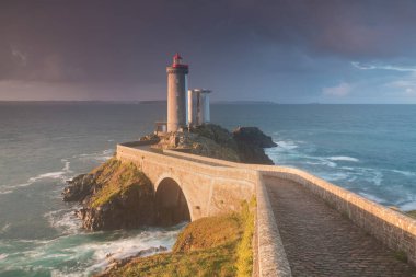 Fırtınalı havalarda Avrupa 'nın en popüler deniz feneri. Gün batımında Petit Minou Deniz Feneri 'nde kırmızı ışık, Brest, Fransa' nın Brittany 'deki Petit Minou Deniz Feneri manzaralı. Yaz mevsimi, Fransa kıyı şeridi