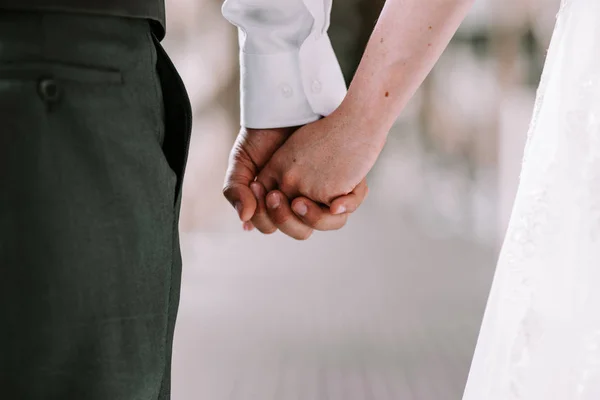 Bruid en bruidegom hand in hand tijdens het lopen — Stockfoto