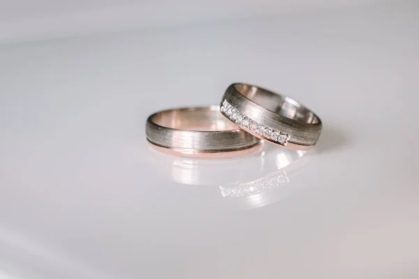 Zlaté snubní prsteny na bílém stole — Stock fotografie