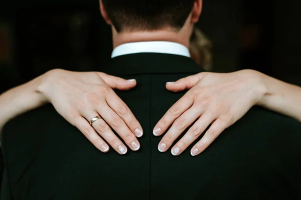 Bruid handen met ringen op de achterkant van de bruidegom — Stockfoto