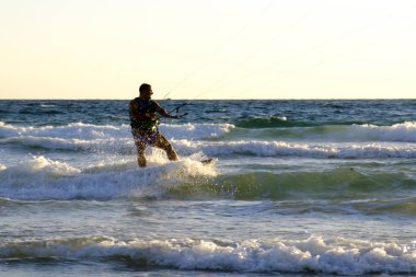 İsrail - Netanya, 15 Ekim 2017: genç bir adam - bir uçurtma sörfçü bir uçurtma Akdeniz dalgalar üzerinde sürmek