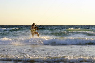 İsrail - Netanya, 15 Ekim 2017: genç bir adam - bir uçurtma sörfçü bir uçurtma Akdeniz dalgalar üzerinde sürmek