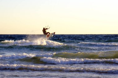 İsrail - Netanya, 15 Ekim 2017: genç bir adam - bir uçurtma sörfçü bir uçurtma Akdeniz dalgalar üzerinde sürmek
