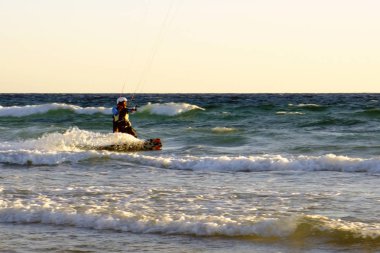 İsrail - Netanya, 15 Ekim 2017: genç bir adam - bir uçurtma sörfçü bir uçurtma Akdeniz dalgalar üzerinde sürmek