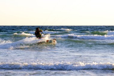 İsrail - Netanya, 15 Ekim 2017: genç bir adam - bir uçurtma sörfçü bir uçurtma Akdeniz dalgalar üzerinde sürmek