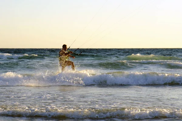 İsrail - Netanya, 15 Ekim 2017: genç bir adam - bir uçurtma sörfçü bir uçurtma Akdeniz dalgalar üzerinde sürmek