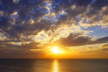 parlak turuncu günbatımı ve mavi Akdeniz ve İsrail mavi gökyüzünde üzerinde yağmur bulutları