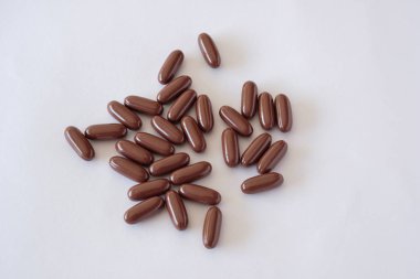 Vitamin hapı Tıbbi preparatlar biyolojik hapları tarçın renkli oval yalan beyaz bir arka plan üzerinde kaotik bir sırada takviyeleri