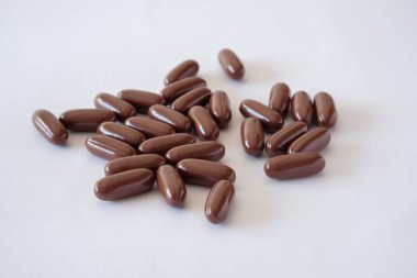 Vitamin hapı Tıbbi preparatlar biyolojik hapları tarçın renkli oval yalan beyaz bir arka plan üzerinde kaotik bir sırada takviyeleri
