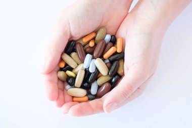 vitamin hapları ilaçlar biyolojik hapları çok renkli oval yuvarlak yalan bir kadın palm üzerinde beyaz bir arka plan üzerinde kaotik bir sırada takviyeleri