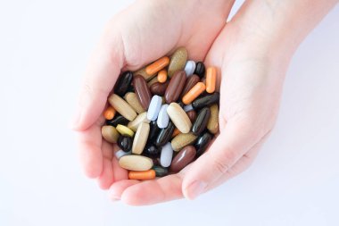 vitamin hapları ilaçlar biyolojik hapları çok renkli oval yuvarlak yalan bir kadın palm üzerinde beyaz bir arka plan üzerinde kaotik bir sırada takviyeleri