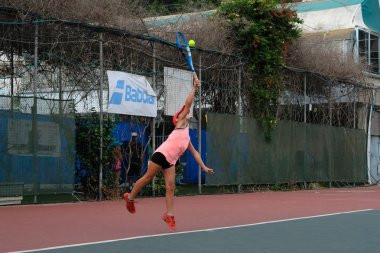 İsrail - Netanya, 27 Temmuz 2018: İsrail yarışmalarda sarayda top yapar vuruş büyük gürültü ile spor tenis Tenis swarty bir besleme oynayan kız genç çalışır