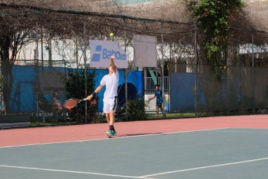 İsrail - Netanya, 27 Temmuz 2018: genç bir adam bir spor gömlek ve spor şort tenis kortunda tenis oynuyor