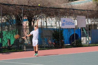 İsrail - Netanya, 27 Temmuz 2018: genç bir adam bir spor gömlek ve spor şort tenis kortunda tenis oynuyor