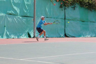 İsrail - Netanya, 27 Temmuz 2018: genç bir adam bir spor gömlek ve spor şort tenis kortunda tenis oynuyor
