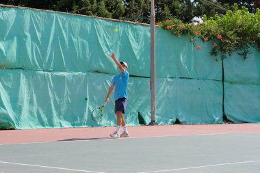 İsrail - Netanya, 27 Temmuz 2018: genç bir adam bir spor gömlek ve spor şort tenis kortunda tenis oynuyor