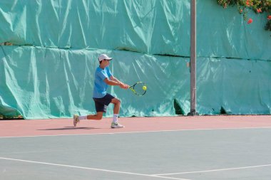 İsrail - Netanya, 27 Temmuz 2018: genç bir adam bir spor gömlek ve spor şort tenis kortunda tenis oynuyor