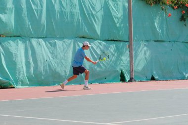 İsrail - Netanya, 27 Temmuz 2018: genç bir adam bir spor gömlek ve spor şort tenis kortunda tenis oynuyor