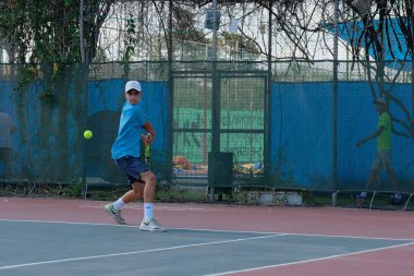 İsrail - Netanya, 27 Temmuz 2018: genç bir adam bir spor gömlek ve spor şort tenis kortunda tenis oynuyor