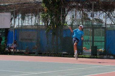 İsrail - Netanya, 27 Temmuz 2018: genç bir adam bir spor gömlek ve spor şort tenis kortunda tenis oynuyor
