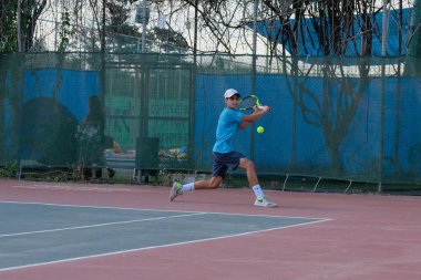İsrail - Netanya, 27 Temmuz 2018: genç bir adam bir spor gömlek ve spor şort tenis kortunda tenis oynuyor