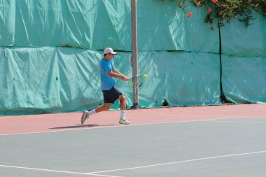 İsrail - Netanya, 27 Temmuz 2018: genç bir adam bir spor gömlek ve spor şort tenis kortunda tenis oynuyor