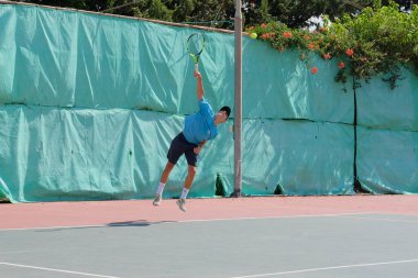 İsrail - Netanya, 27 Temmuz 2018: genç bir adam bir spor gömlek ve spor şort tenis kortunda tenis oynuyor