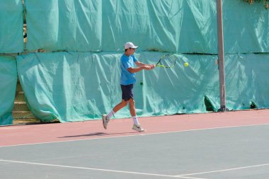 İsrail - Netanya, 27 Temmuz 2018: genç bir adam bir spor gömlek ve spor şort tenis kortunda tenis oynuyor