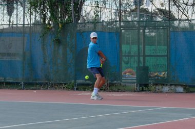 İsrail - Netanya, 27 Temmuz 2018: genç bir adam bir spor gömlek ve spor şort tenis kortunda tenis oynuyor