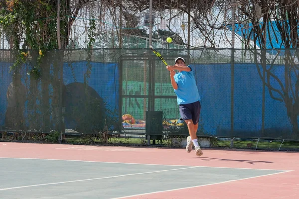 İsrail - Netanya, 27 Temmuz 2018: genç bir adam bir spor gömlek ve spor şort tenis kortunda tenis oynuyor