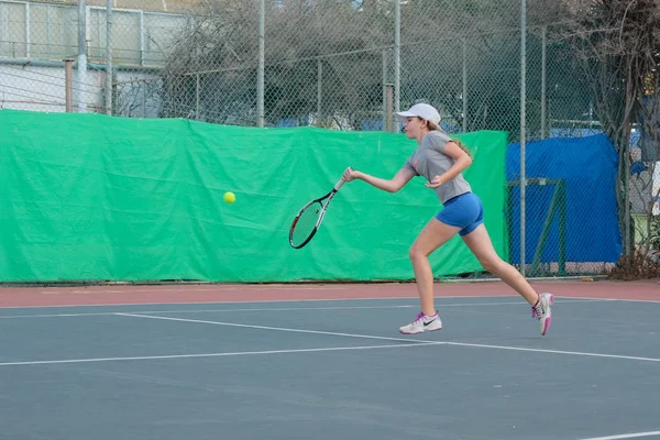 イスラエル ネタニヤ 2018 スポーツ ショート パンツのスポーツ シャツで若い女の子テニス裁判所ビート走るボールがイスラエル共和国の大会でファイリングを実行 — ストック写真
