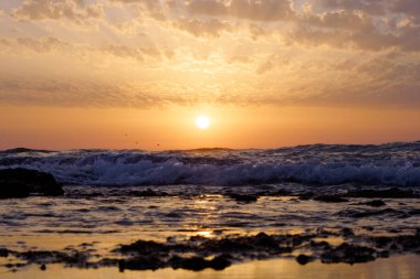 günbatımı ve gökyüzü ve deniz ve dalgalar ve Akdeniz'de İsrail üzerinde bulutlar