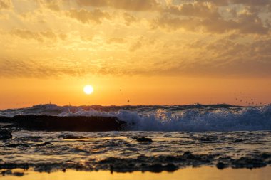 günbatımı ve gökyüzü ve deniz ve dalgalar ve Akdeniz'de İsrail üzerinde bulutlar