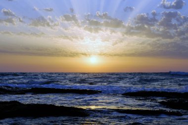 günbatımı ve gökyüzü ve deniz ve dalgalar ve Akdeniz'de İsrail üzerinde bulutlar