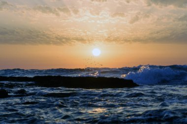günbatımı ve gökyüzü ve deniz ve dalgalar ve Akdeniz'de İsrail üzerinde bulutlar