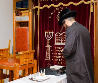 the moel in the synagogue prays before circumcision clipart