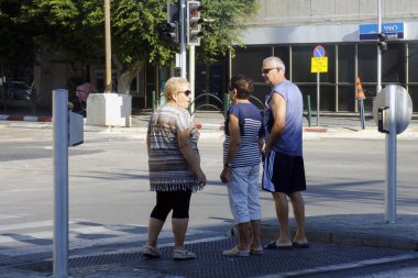 İsrail - Netanya, 12 Ekim 2017: iki kadın ve bir adam yaşlı çapraz yol üzerinde bir yaya geçidi