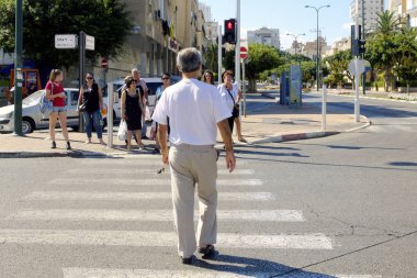 İsrail - Netanya, 13 Ekim 2017: ihtiyar bir adamın yolun kırmızı ışık yaya geçidi üzerinde haçlar