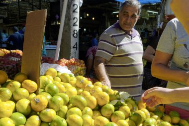 İsrail - Netanya, 13 Ekim 2017: yaşlı bir adam mandalina şehir piyasada seçer.