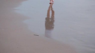 Genç bir çocuğun genç ayaklar gün batımından sonra Akdeniz pembe renk kıyılarında yürümek