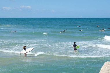 ISAREL - Herzliya, 29 Mayıs 2020: Karantina kaldırıldıktan sonra büyük bir grup sörfçü denizde sörf yapıyor.