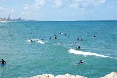 ISAREL - Herzliya, 29 Mayıs 2020: Karantina kaldırıldıktan sonra büyük bir grup sörfçü denizde sörf yapıyor.