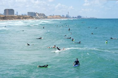 ISAREL - Herzliya, 29 Mayıs 2020: Karantina kaldırıldıktan sonra büyük bir grup sörfçü denizde sörf yapıyor.