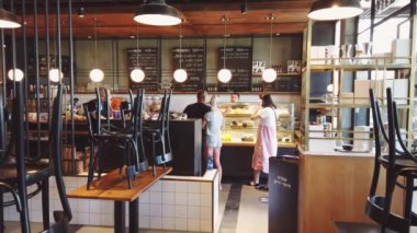 ISRAEL - Tel Aviv, 23 Mayıs 2020: Karantina kısıtlamalarını kaldırdıktan sonra tıbbi maskeli insanlar tel aviv cafe 'den yemek sipariş ettiler