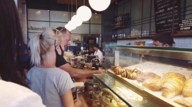 ISRAEL - Tel Aviv, 23 Mayıs 2020: Karantina kısıtlamalarını kaldırdıktan sonra tıbbi maskeli insanlar tel aviv cafe 'den yemek sipariş ettiler