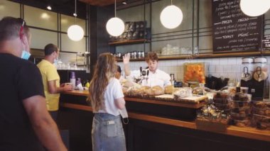ISRAEL - Tel Aviv, 23 Mayıs 2020: Karantina kısıtlamalarını kaldırdıktan sonra tıbbi maskeli insanlar tel aviv cafe 'den yemek sipariş ettiler