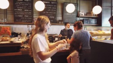 ISRAEL - Tel Aviv, 23 Mayıs 2020: Karantina kısıtlamalarını kaldırdıktan sonra tıbbi maskeli insanlar tel aviv cafe 'den yemek sipariş ettiler