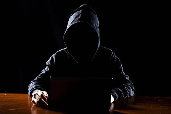 Hacker in front of his computer. Dark face